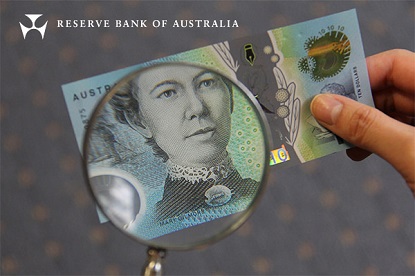 Image shows a new $10 note being looked at through a magnifying glass