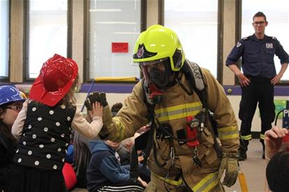 A firefighter gives a young Vision Australia Client a high five