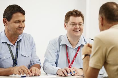 VA client grant sits with a VA employee and another man at a table