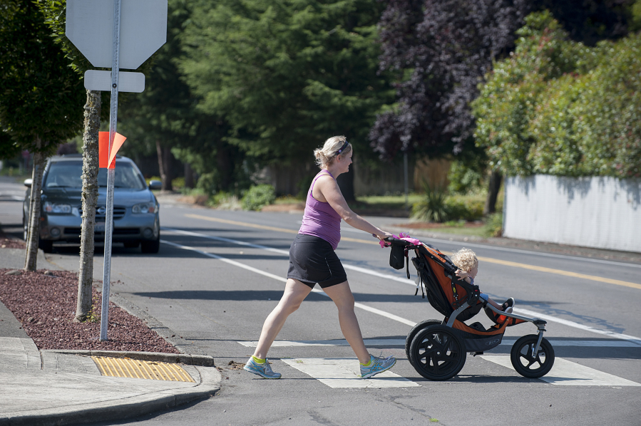 Woman crossing a road whilst pushing a pram