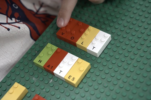 A selection of LEGO Braille bricks spell out the word volt