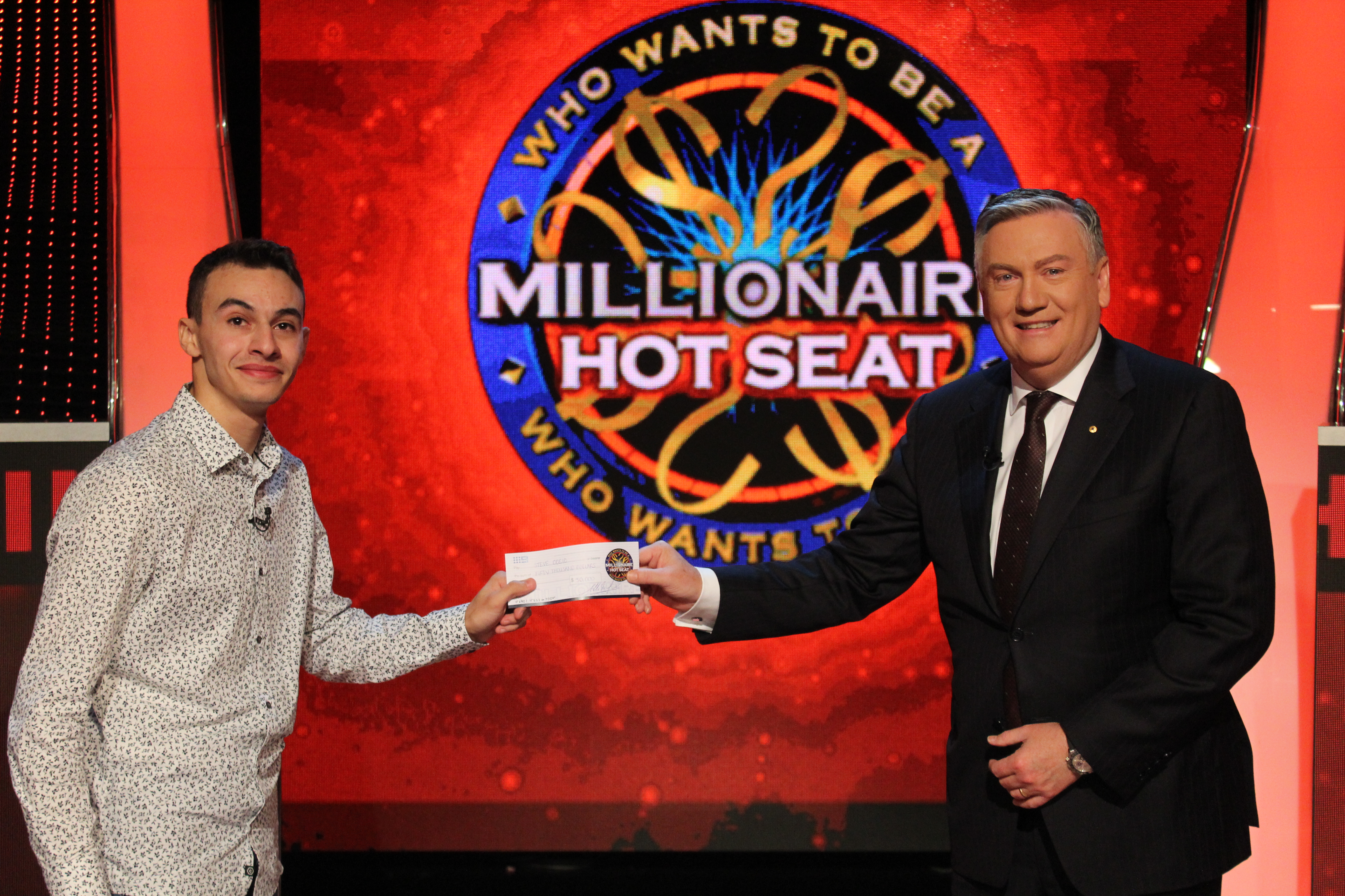 "Steve receiving his cheque from Eddie McGuire, host of Millionaire Hot Seat"