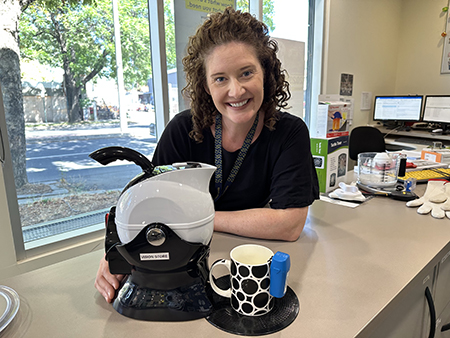 Occupational Therapist Alex Lonsdale smiling beside a black and white Uccello Kettle