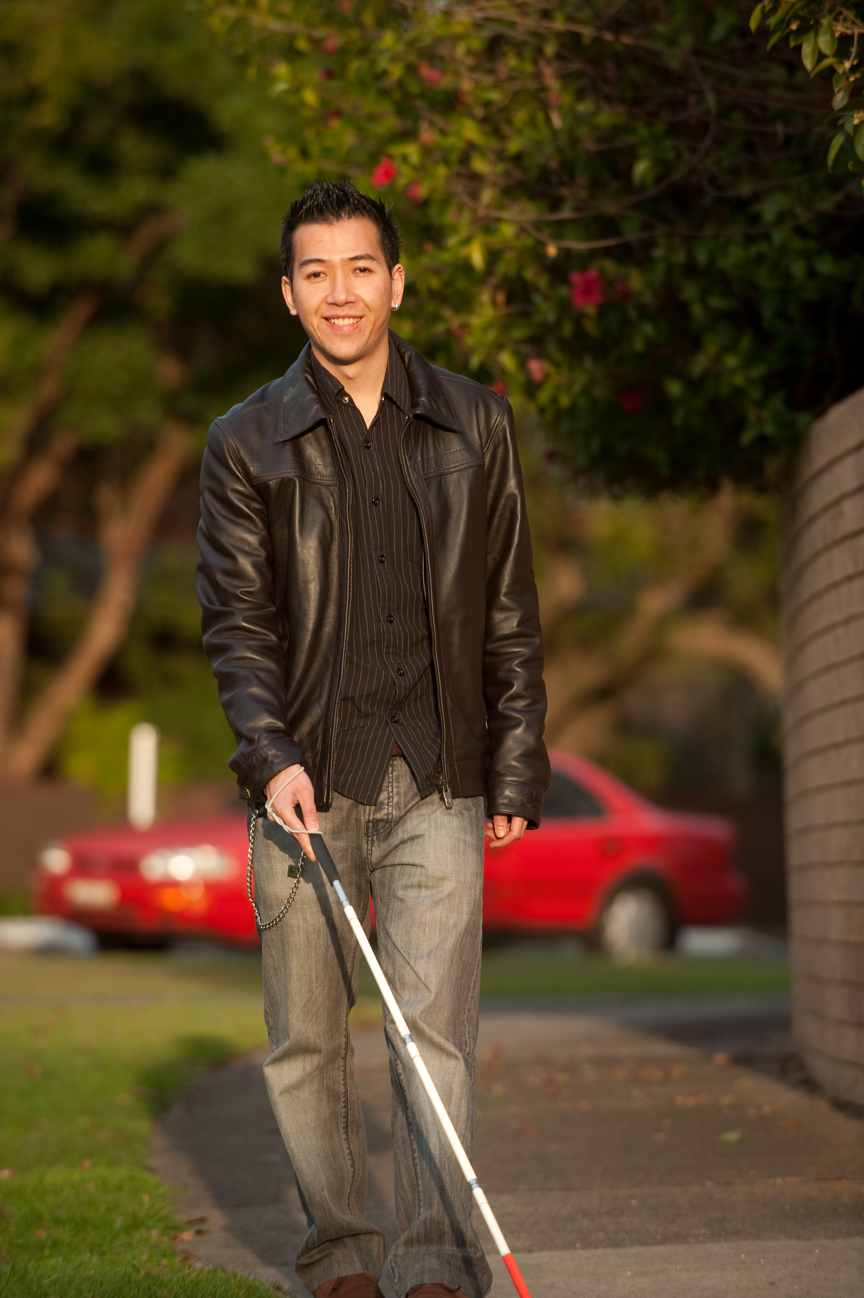 Photo of Dawson walking along a footpath using his cane