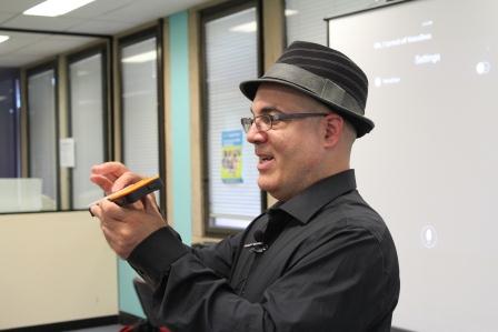 Photo of Luis demonstrating a device to the audience