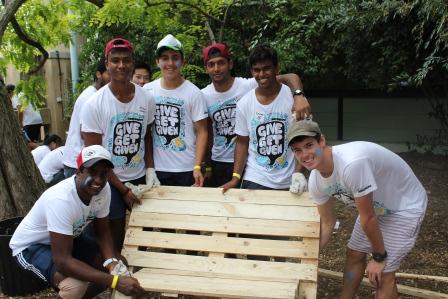group of young volunteers from Optus Rock Corps start work on creating a bench seat for sensory garden