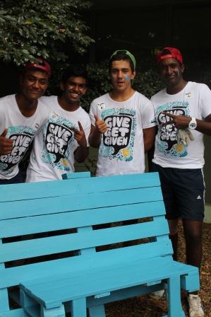 group of young volunteers proudly show off the finshed bench