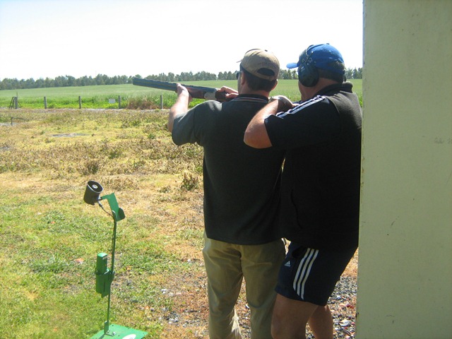 Photo of participant aiming the gun with assistance from another person to angle