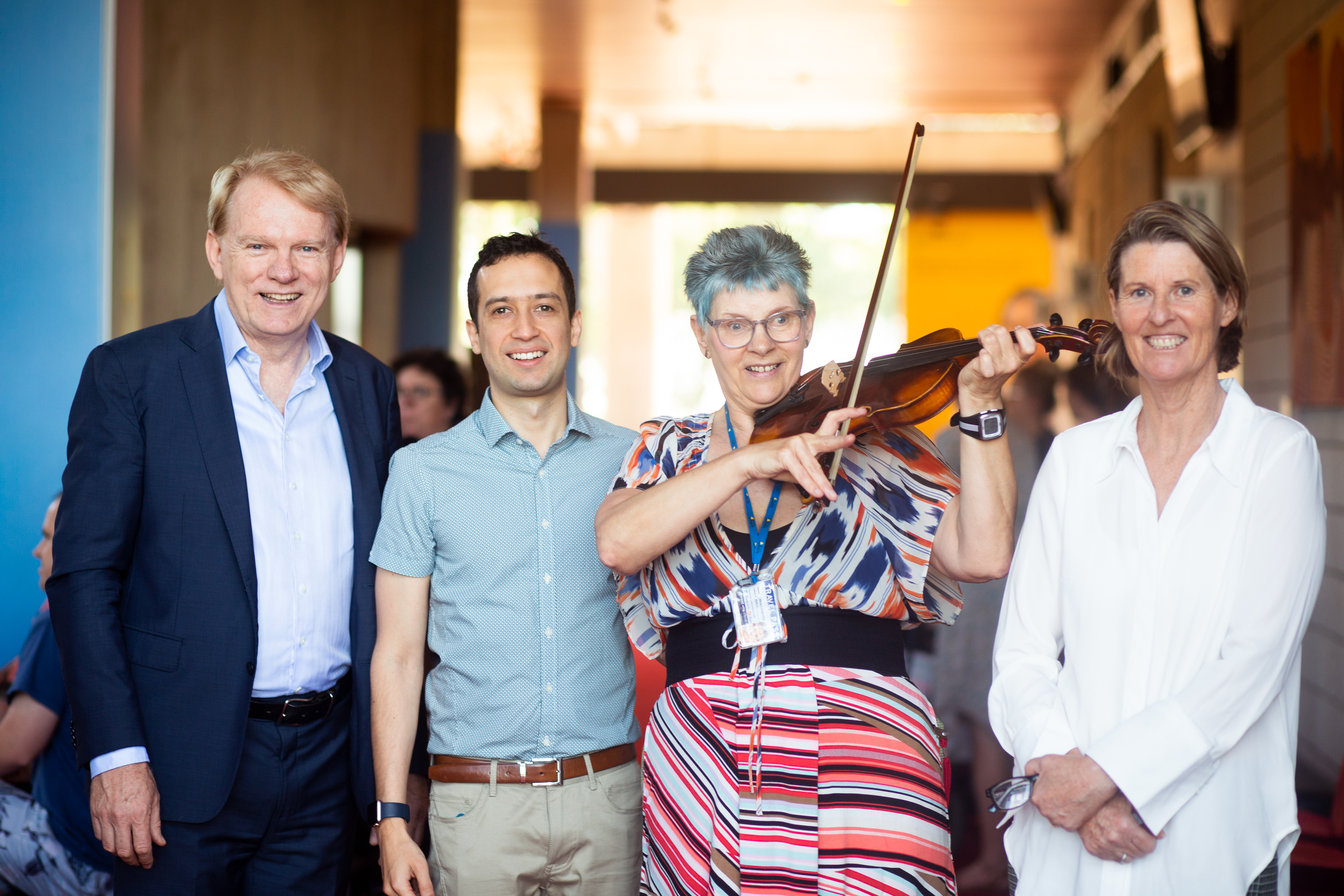 CEO of WASO Mark Coughlan, violinist, Wilma and a WASO staff member standing together, Wilma is playing the violin. Photos by Alanna Kusin, WASO.