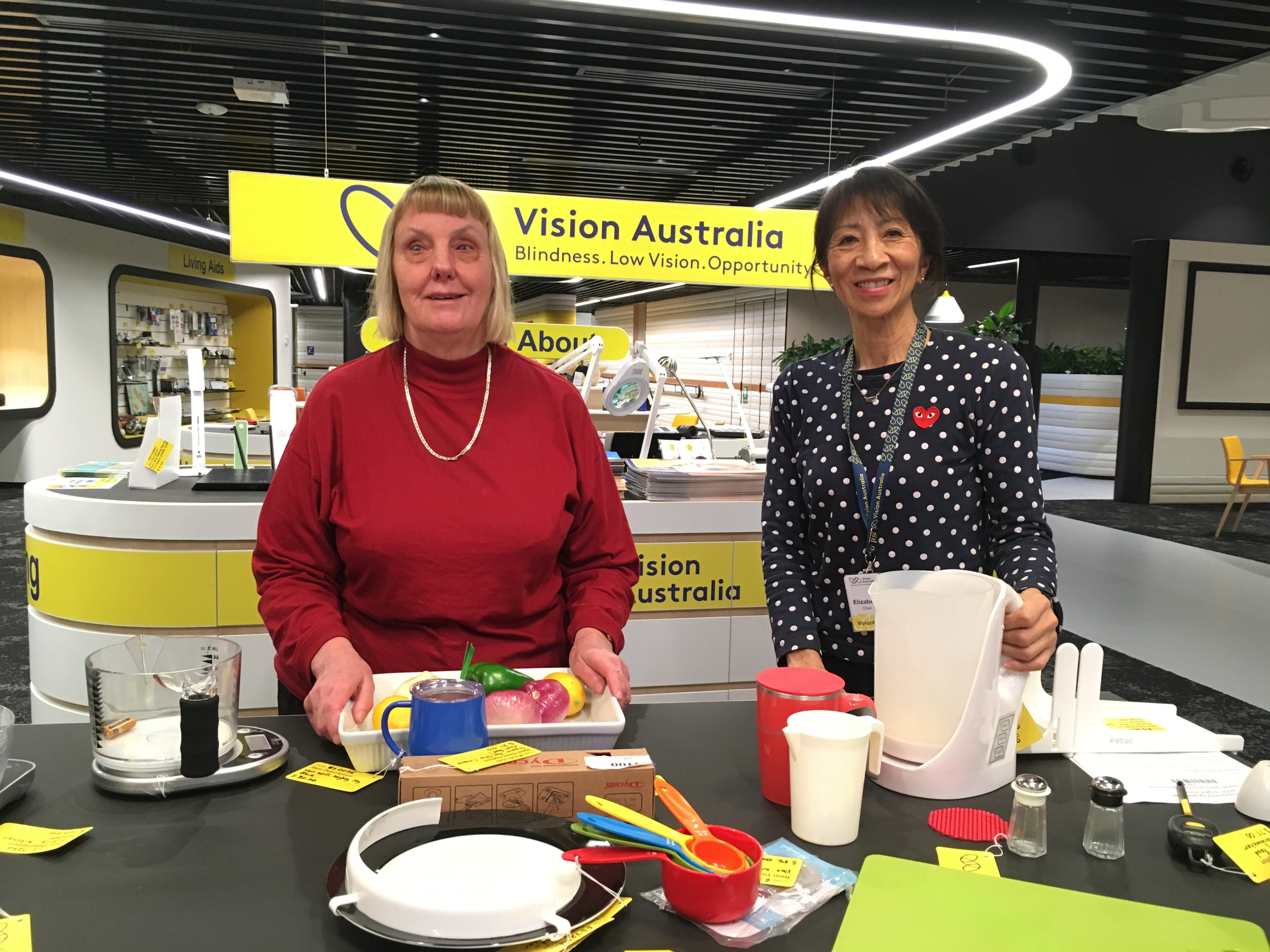 Food for Thought presenters Joy Nuske and Liz Chen with kitchen utensils at the Vision Australia store in Kooyong