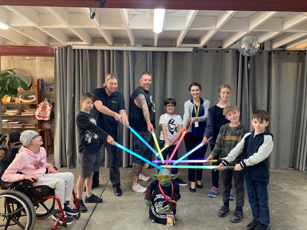 Event participants all posing for a photo at the end of a productive lesson in light saber combat
