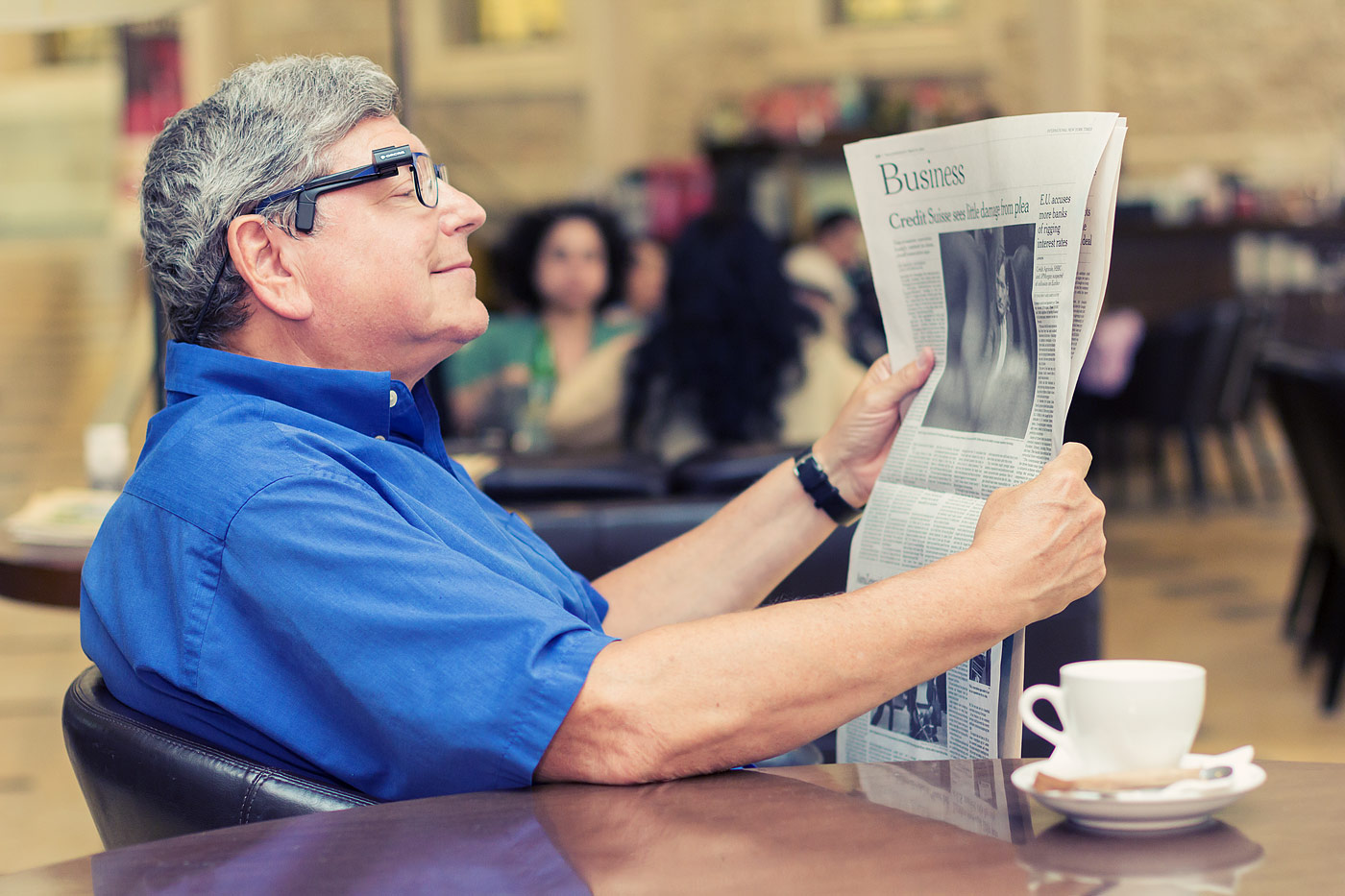 A man using his Orcam MyEye to read the newspaper