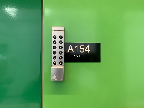 A green locker with a silver keypad