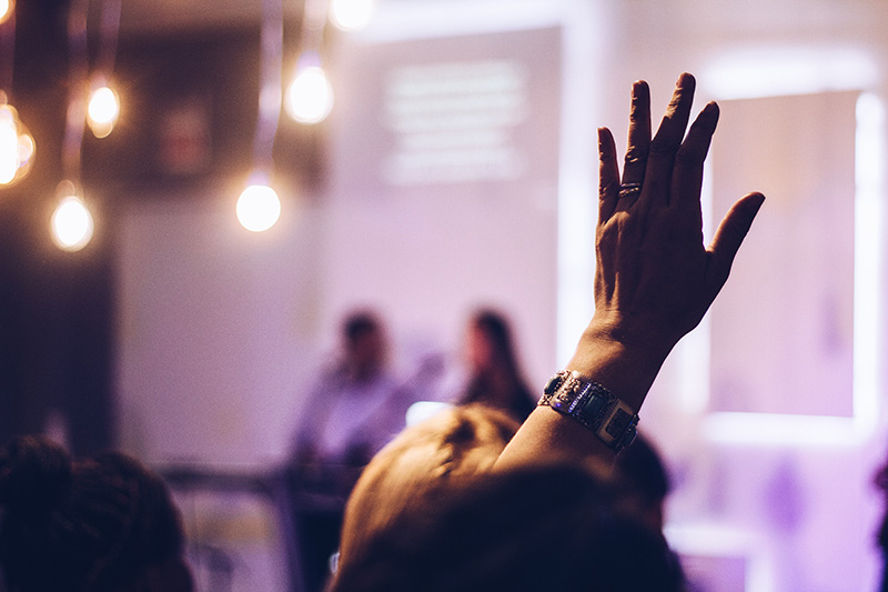 A person raises a hand at a church service
