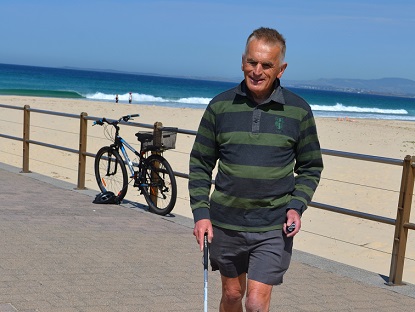 Geoff walking with his white can along his local beach