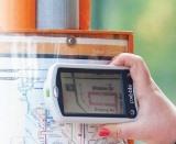 Woman using magnifier to read bus timetable