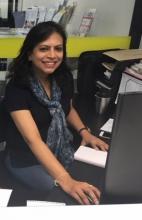 Local volunteer Usha Rangaraj behind the desk in Vision Australia's Epping office