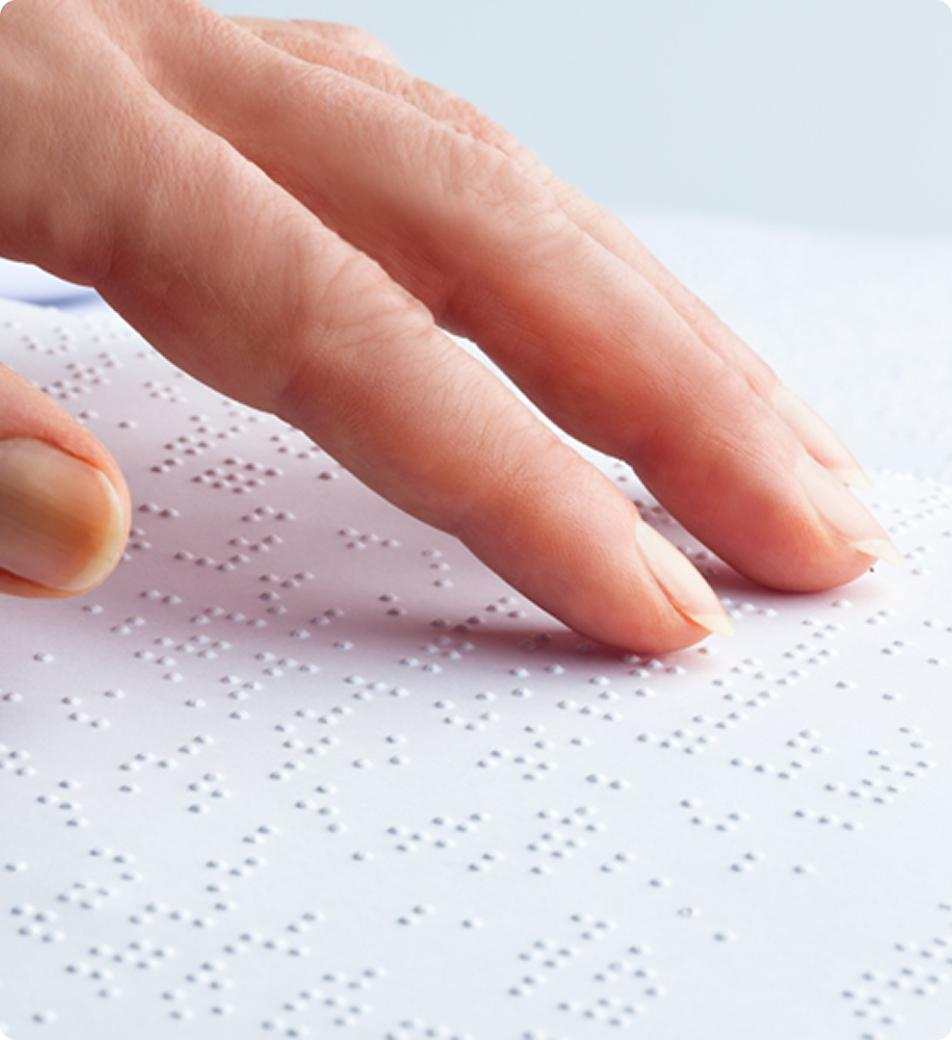 A close up of a hand reading braille text
