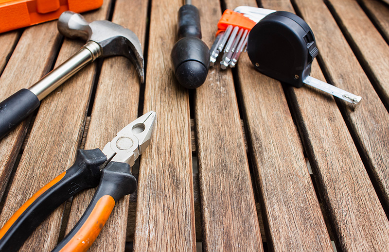 A set of black and orange tools sit on wooden boards